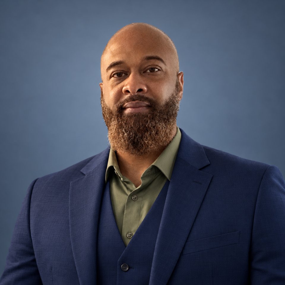 Christopher Milton, founder of Officium Mentale, in a navy suit and olive shirt